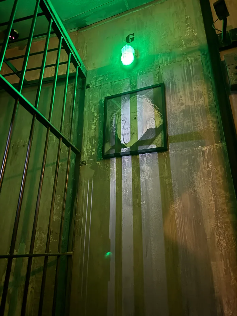 Le portrait d’Einstein sous une lumière verte, à côté des barreaux de The Bunker à Toulouse